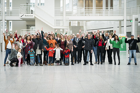 Groepsfoto Jan van Zanen en een grote groep (30+) bezoekers aan het stadhuis, waaronder 5 kinderen op de voorgrond