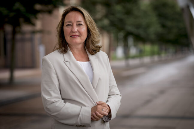 Portretfoto van Saskia Bruines, buiten genomen. Saskia draagt een cremekleurige jas en heeft de handen in elkaar (foto: Valerie Kuypers)