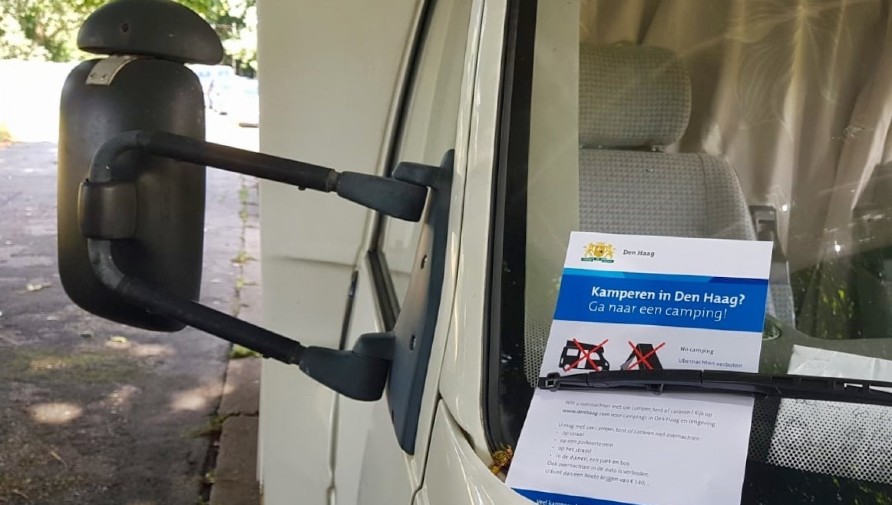 Handhavers en boswachters delen flyers uit aan bezoekers met een camper, caravan of tent. Op de flyer staat dat zij alleen mogen overnachten op een camping.