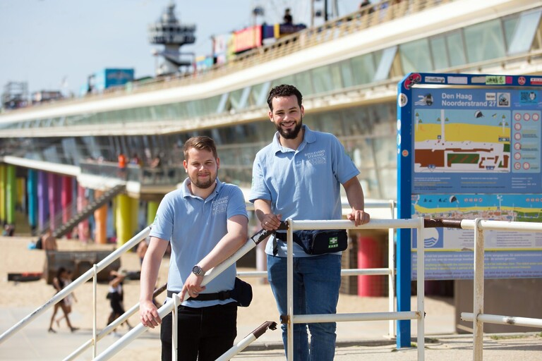 David en Ismael in blauw tenue naast de pier.
