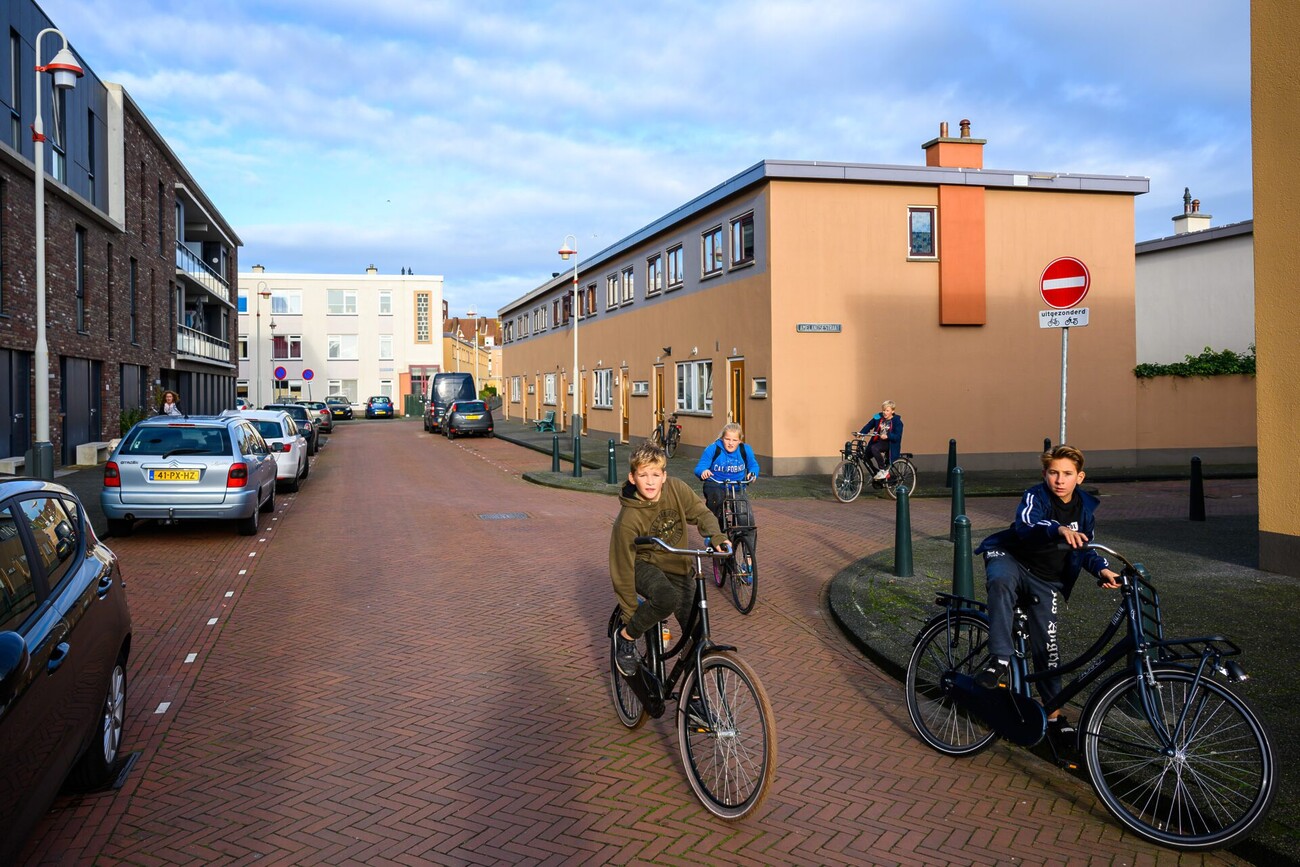 Een foto van een typisch Duindorpse straat, 4 kinderen op de fiets, ongeveer 10 jaar, kijken de camera in.