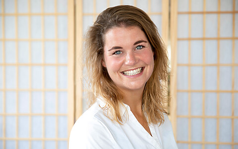 Kelly, vrouw met donkerblond haar en witte blouse