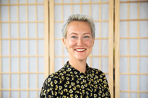 Peggy, wit/grijs haar, ringetje in neus en bloemig shirt aan