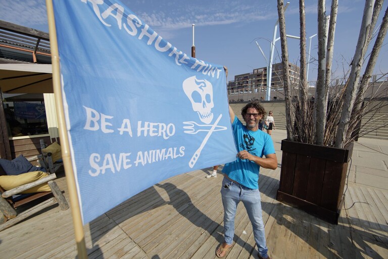 Ralph poseert met een vlag van TrashUre hunt.