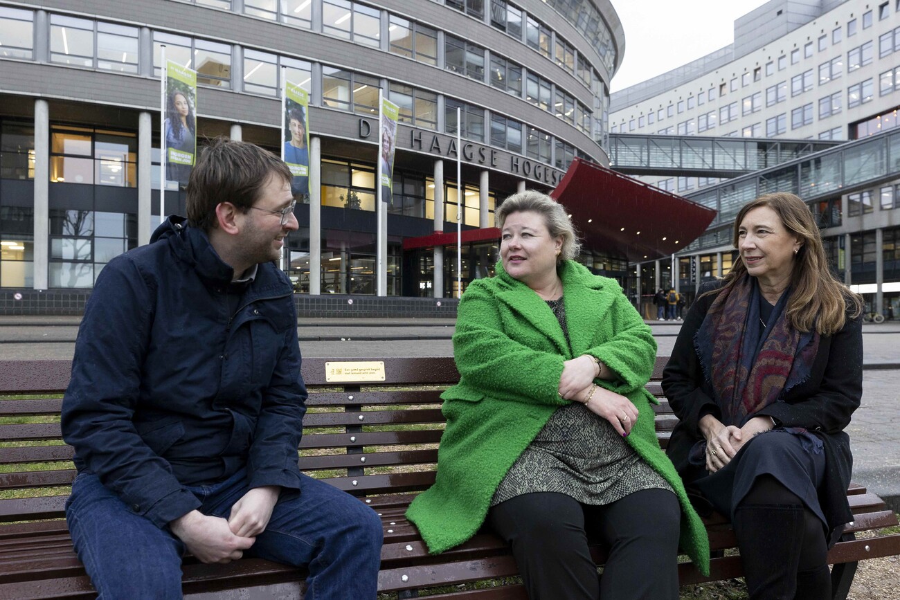 Robert Barker, Marije Mostert en Elisabeth Minnemann op een bankje met gedenkplaatje over zelfdoding.