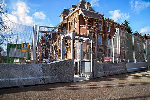 Grote Engelse hekken van zo'n 4 meter hoog sluiten een gedeelte van Den Haag af. Op de foto staat ook een toegangspoort voor de inwoners die in het gebied wonen.