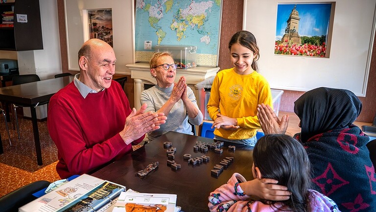 Laurens met nog een vrijwilliger, de Syrische Amina en een paar ander bewoners van he hote tijden he Taalcafe (foto: Arenda Oomen)