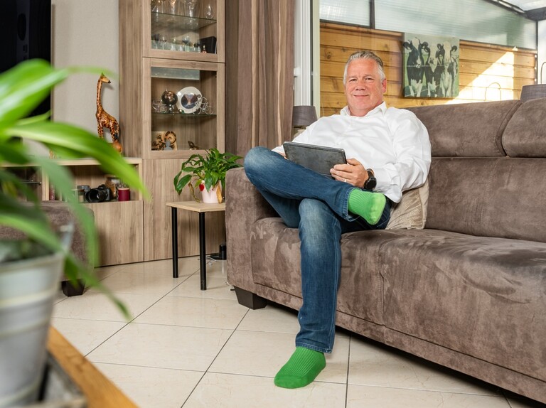 Bewoner zit er comfortabel bij op de bank in zijn huiskamer. Hij heeft zijn vloer geïsoleerd