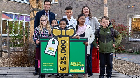 Bewoners uit de Heesterbuurt met een bord van het wijkbudget.