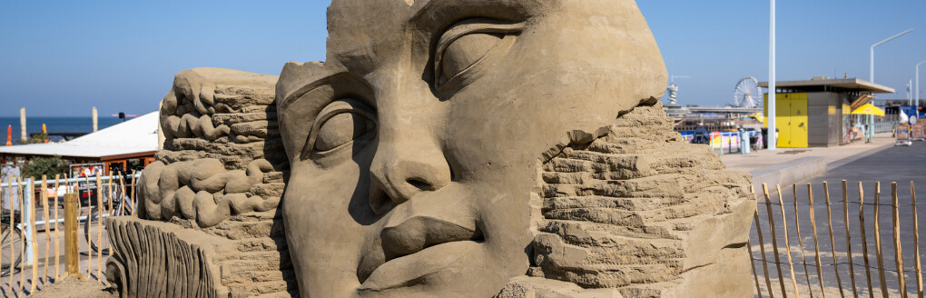Zandsculptuur van een gezicht in Scheveningen.