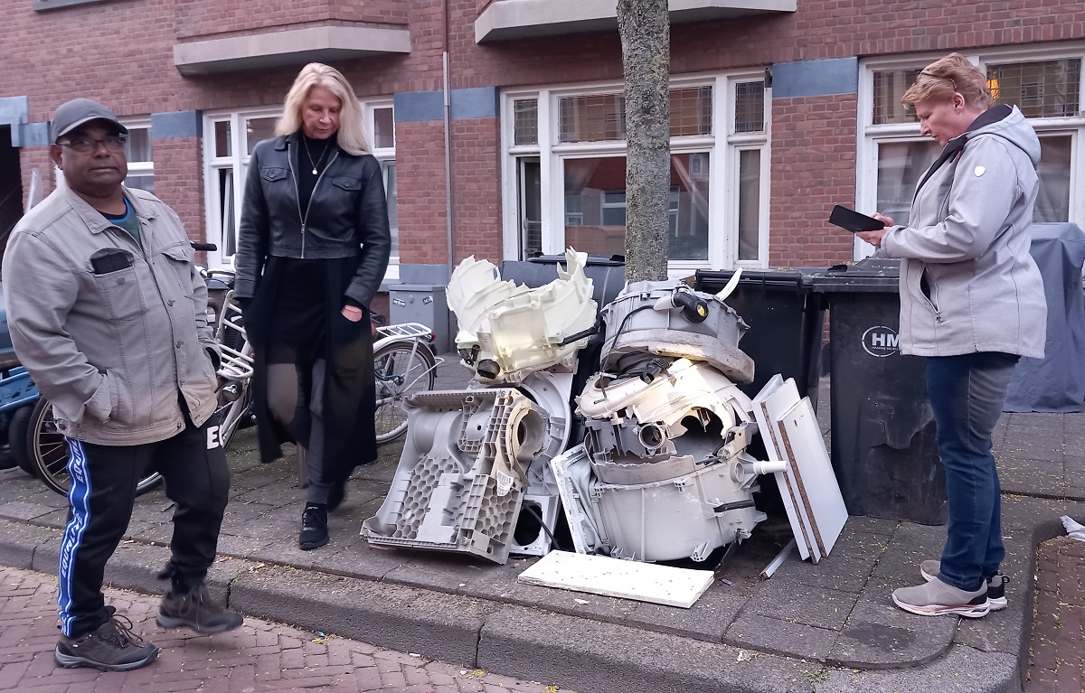 Siew, Yvonne en Manna van Buurtpreventieteam Laak staan bij een berg afval in de wijk.