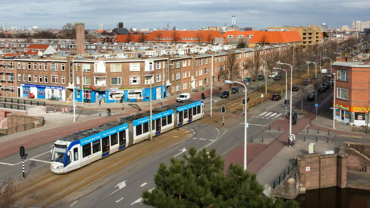 Kruispunt in Rustenburg-Oostbroek. Er rijdt een tram over het kruispunt. Auto's staan in de straten geparkeerd.