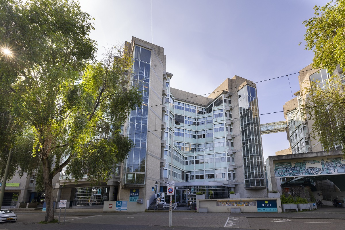 Voormalig ministerie SoZa aan de Anna van Hannoverstraat. Hoog, wit gebouw met veel glas. De gemeente gebruikt het gebouw nu om vluchtelingen en andere groepen mensen op te vangen.