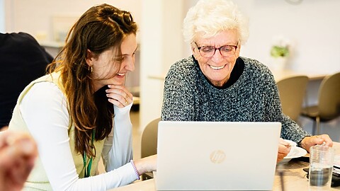 Mevrouw Giny Stobbe-Kruize vult de vragenlijst in op de laptop van een medewerker van de gemeente.