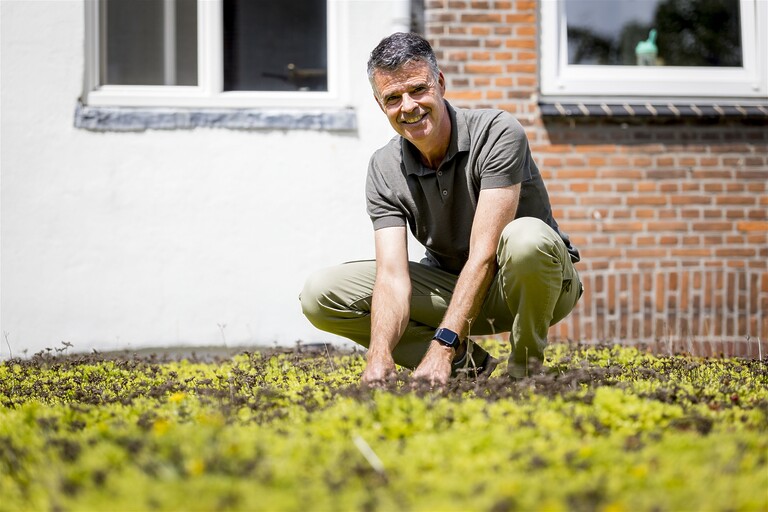 Bewoner Gerben zit op zijn groene dak.