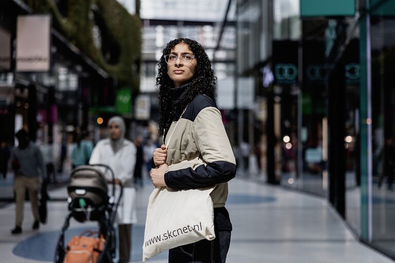 Vrouw kijkt naar iets op straat.