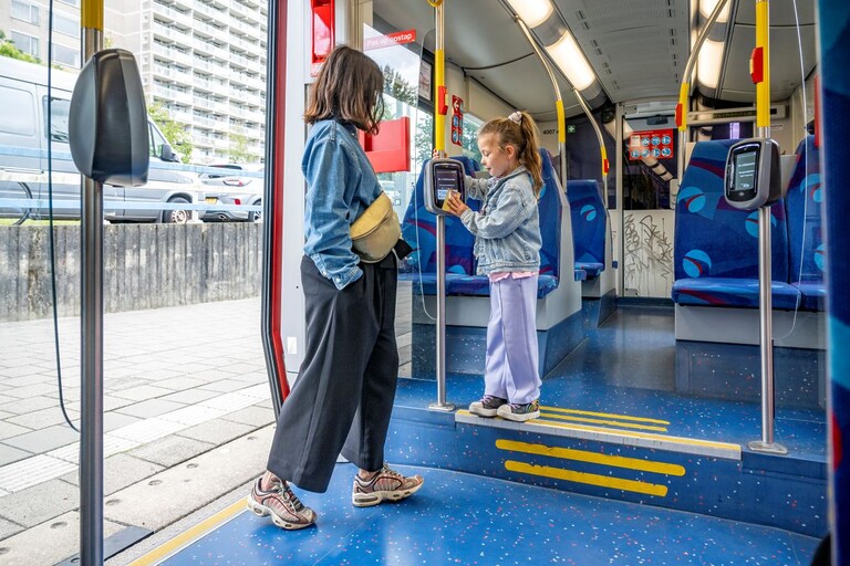 Een meisje in de tram checkt in met haar chipkaart