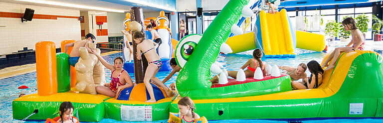 Kinderen spelen op luchtkussens in het water
