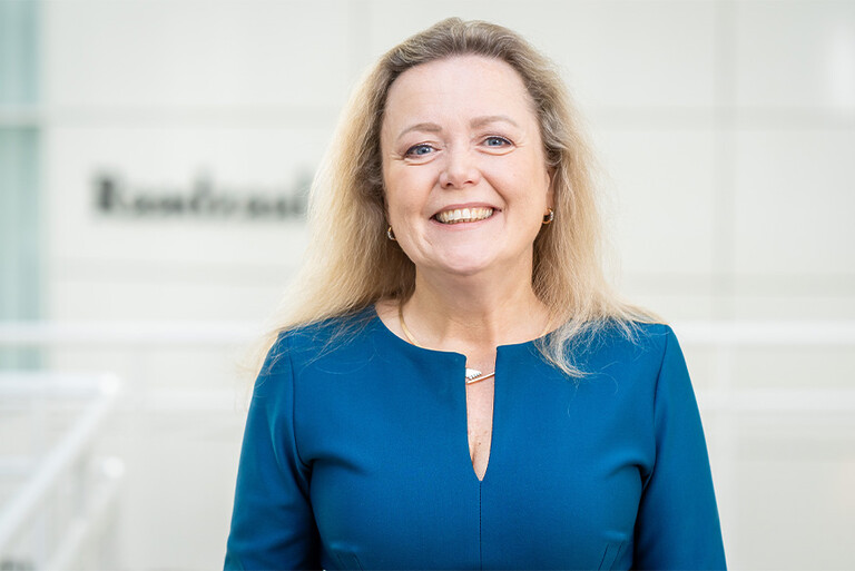 Amanda Lock kijkt lachend in de camera tijdens een portretfoto in het stadhuis van Den Haag