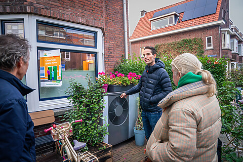 Iemand laat een warmtepomp aan andere mensen zien