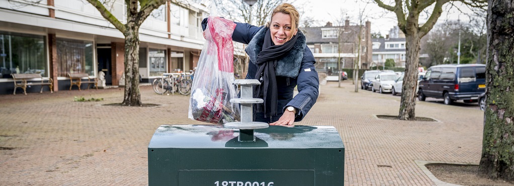 Resident puts clothes in textile container