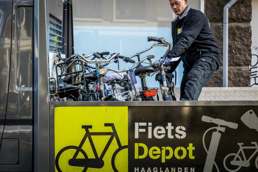 A municipal employee brings a bike to the bicycle depot.